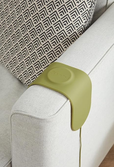 A green charging dock on a sofa arm.